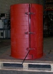 Extreme custom manhole riser, a large tall red steel cylinder with a bolted seam